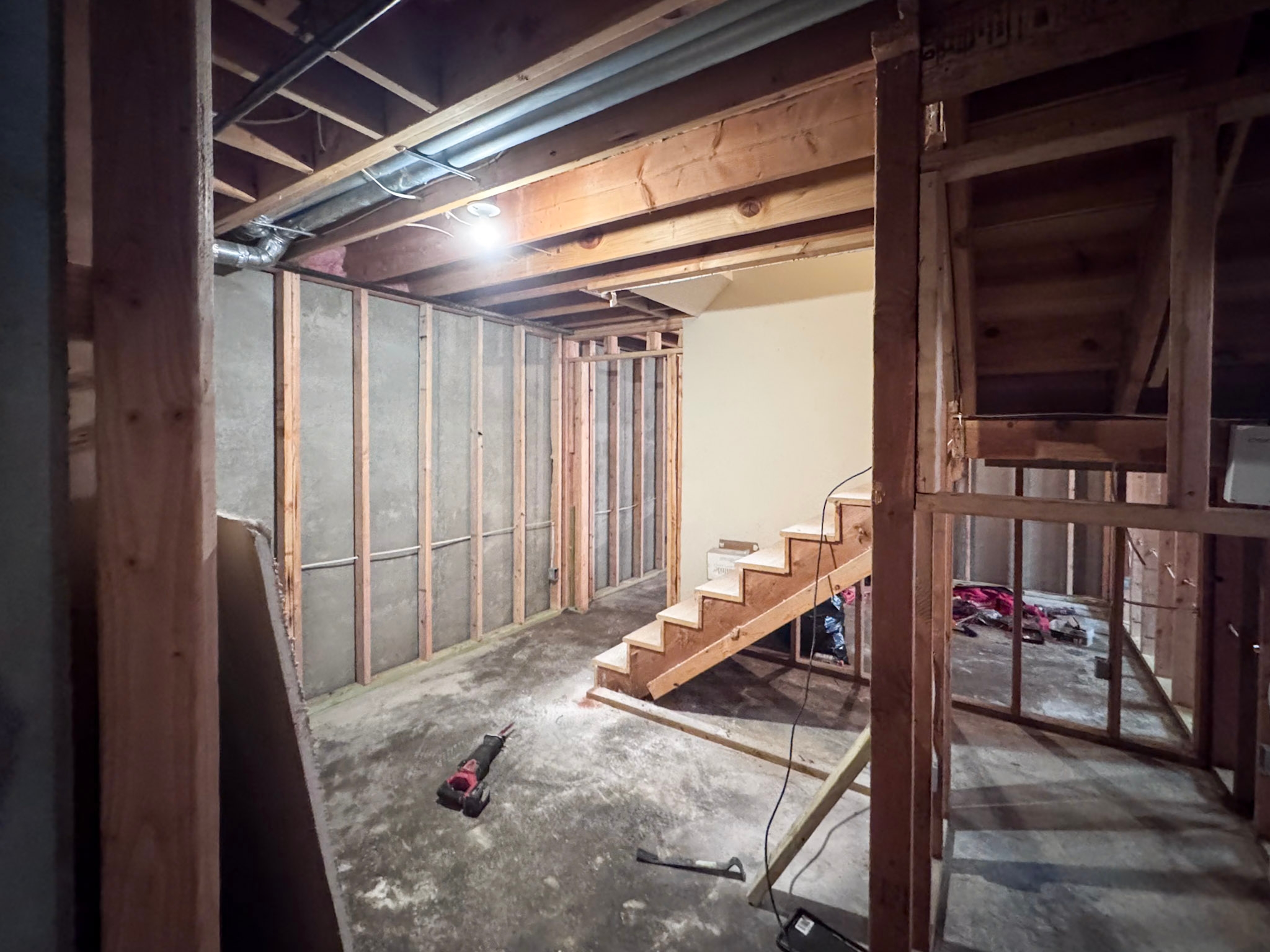 New basement staircase under construction with framed stringers and treads
