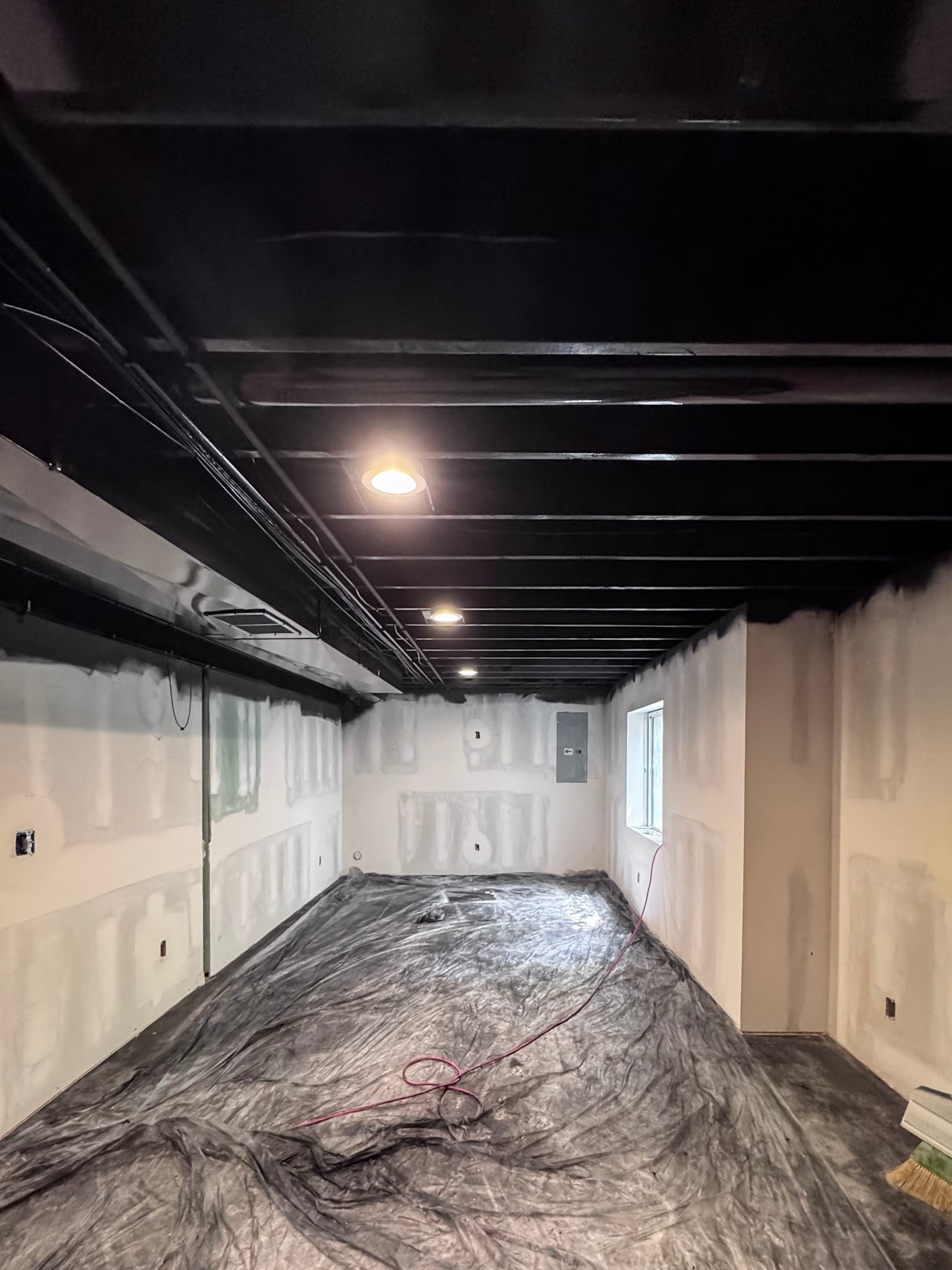 Drywall, painted exposed ceiling, and recessed lighting installed during the remodel