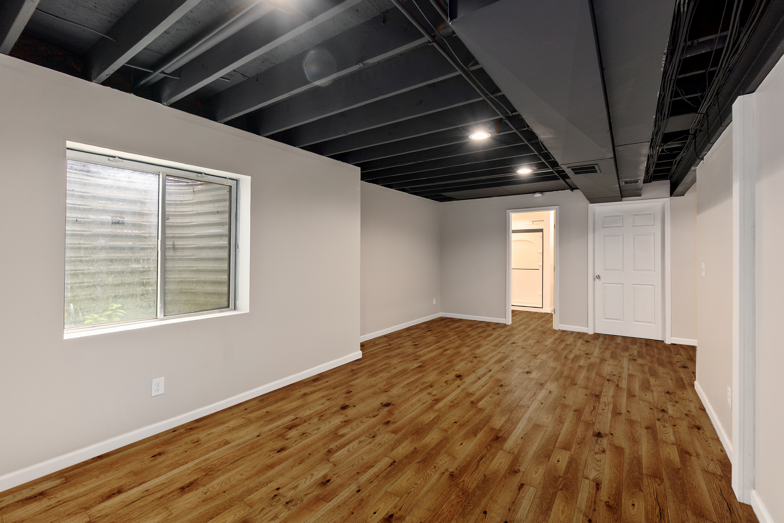 Finished basement hallway with new flooring and doors