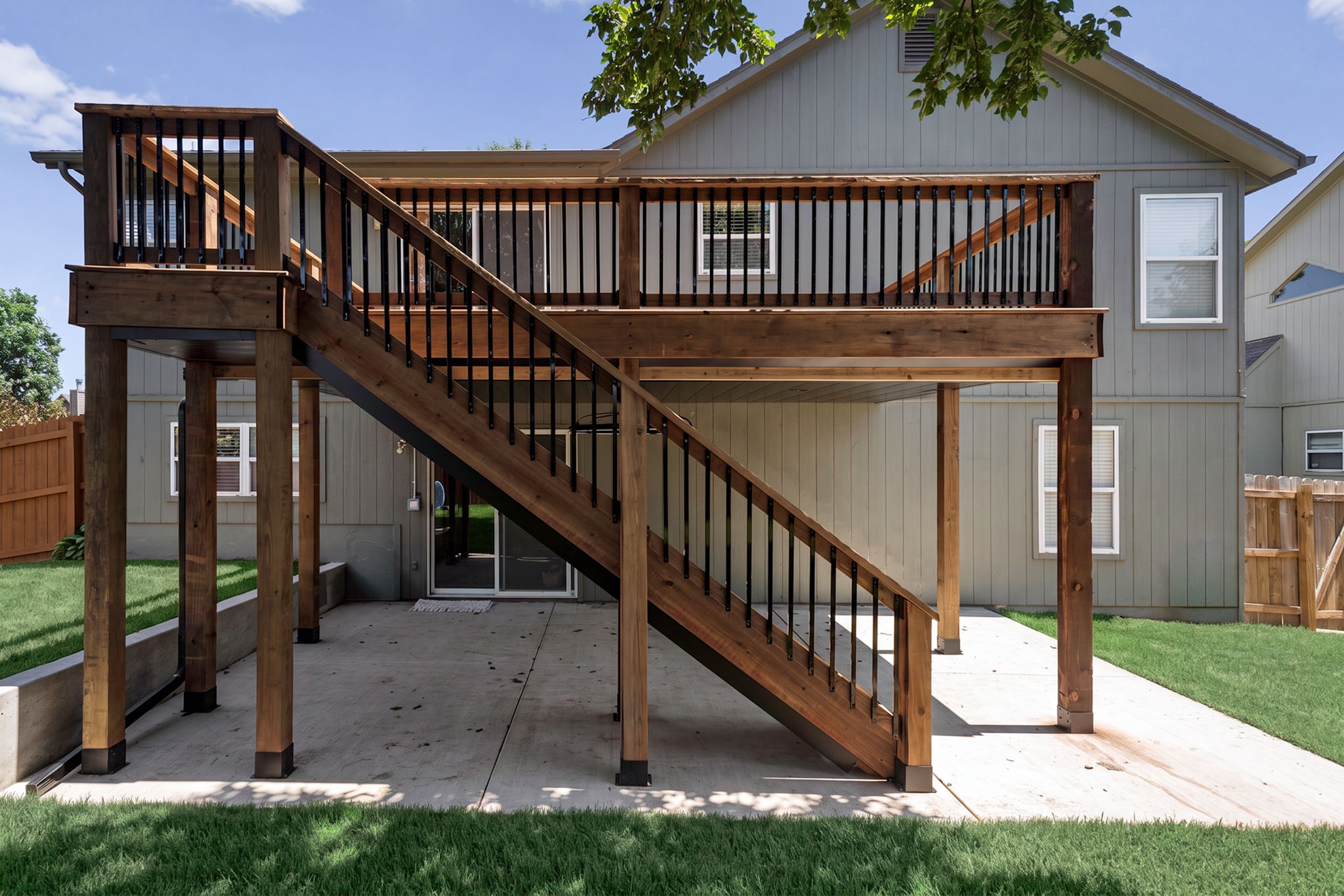 Finished two-level deck with staircase and metal railings, viewed from below