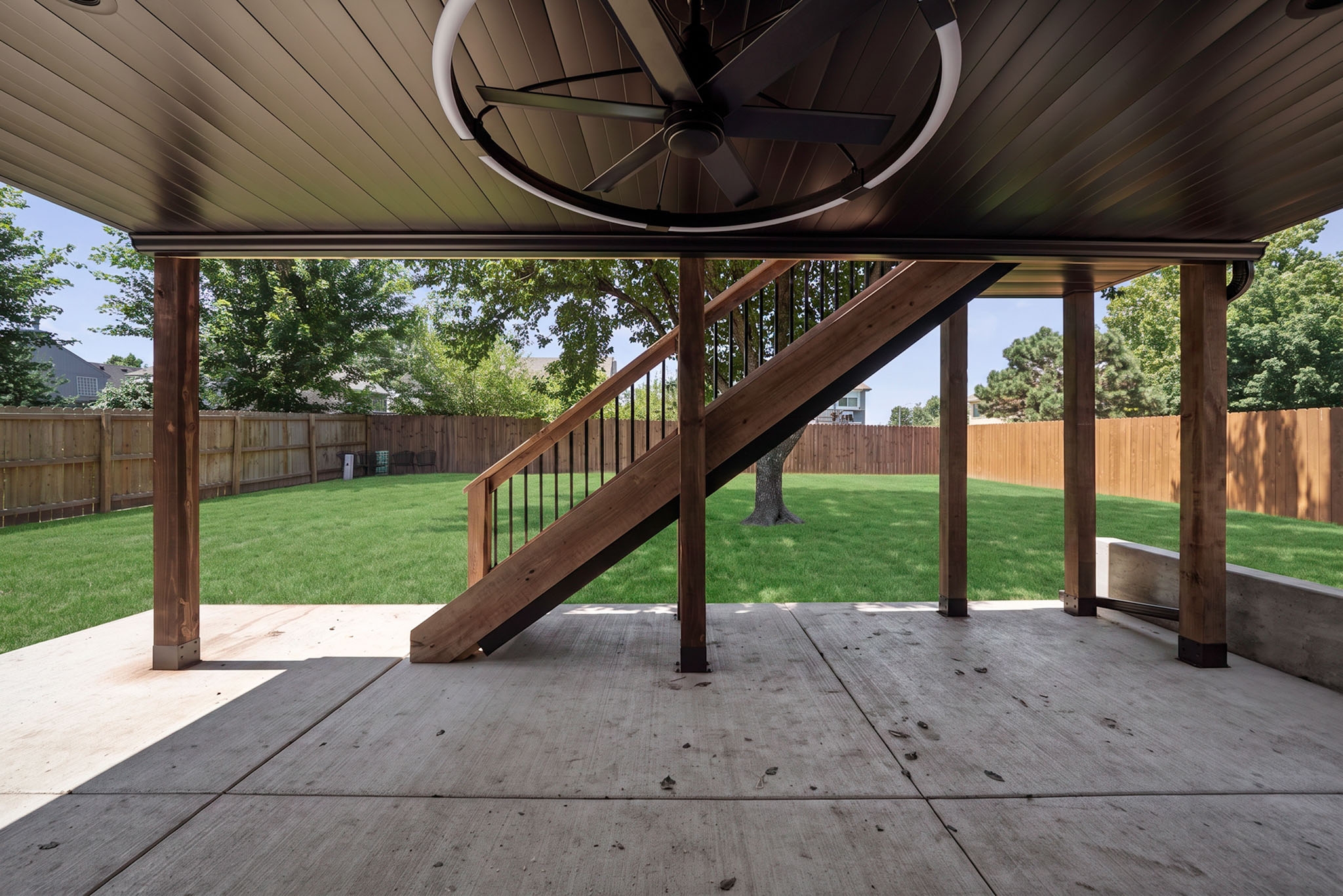 Covered patio beneath the finished deck with a ceiling fan